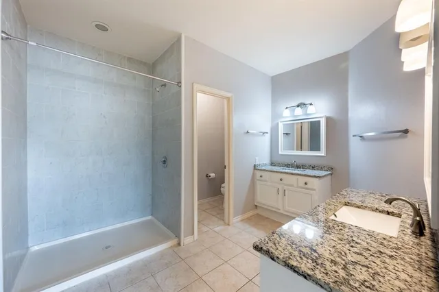 a bathroom with a bathtub shower sink and mirror