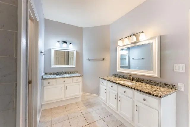 a bathroom with granite countertop a sink and a mirror