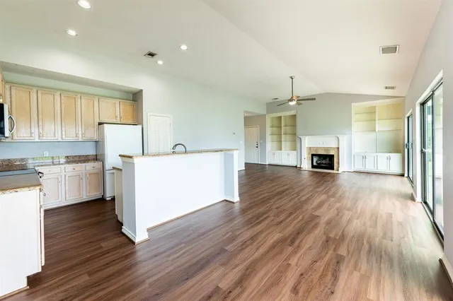 wooden floor fireplace and windows in an empty room