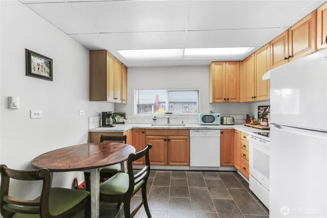 a kitchen with a table chairs microwave and cabinets