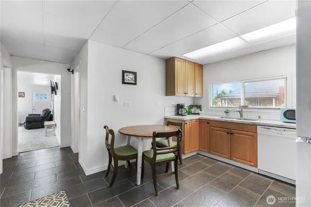 a kitchen with a dining table chairs and white cabinets