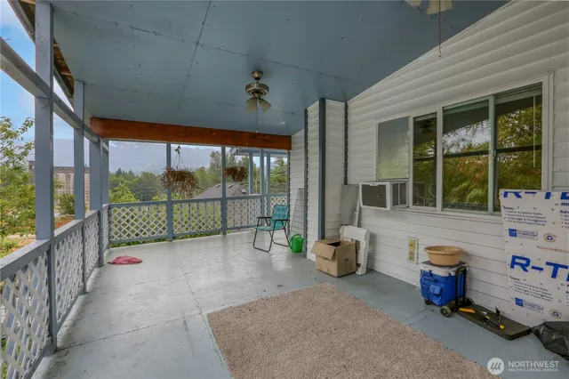 a view of a porch with furniture and floor to ceiling window