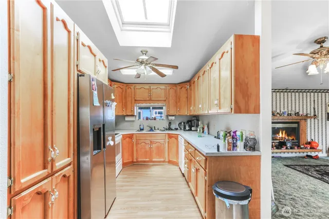 a kitchen with stainless steel appliances granite countertop a refrigerator a sink and white cabinets
