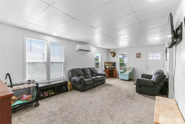 a living room with furniture a large window and a flat screen tv