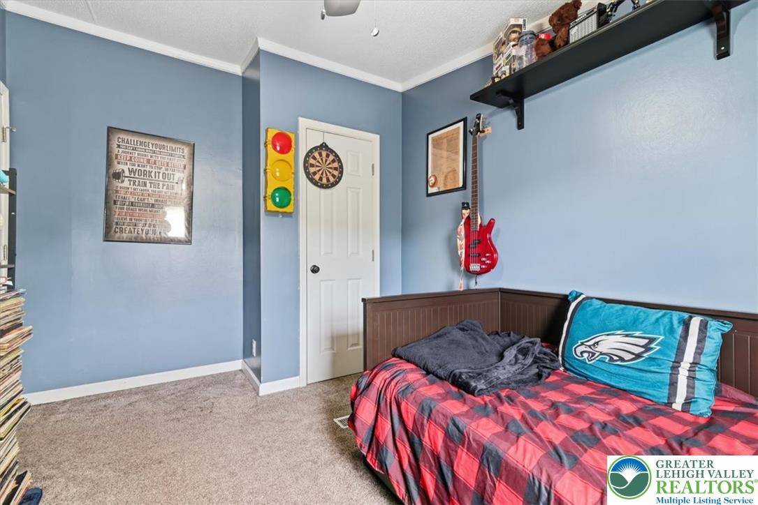 634 Main Road Lehighton, PA 18235 - Photo 28 of 39 A comforting bedroom with warm carpeted floors and crisp crown molding, perfect for restful nights.