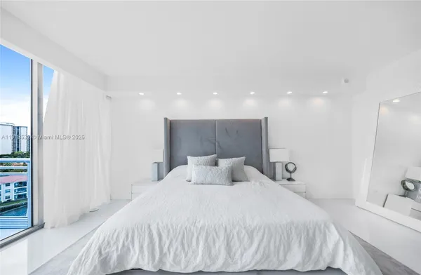 a white kitchen with stainless steel appliances kitchen island granite countertop a sink and cabinets