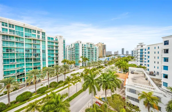 a white bedroom with a bed and a flat screen tv