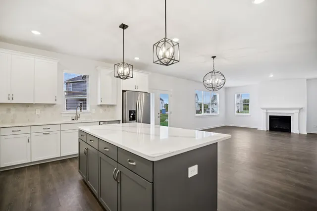 a view of an empty room with wooden floor and stairs