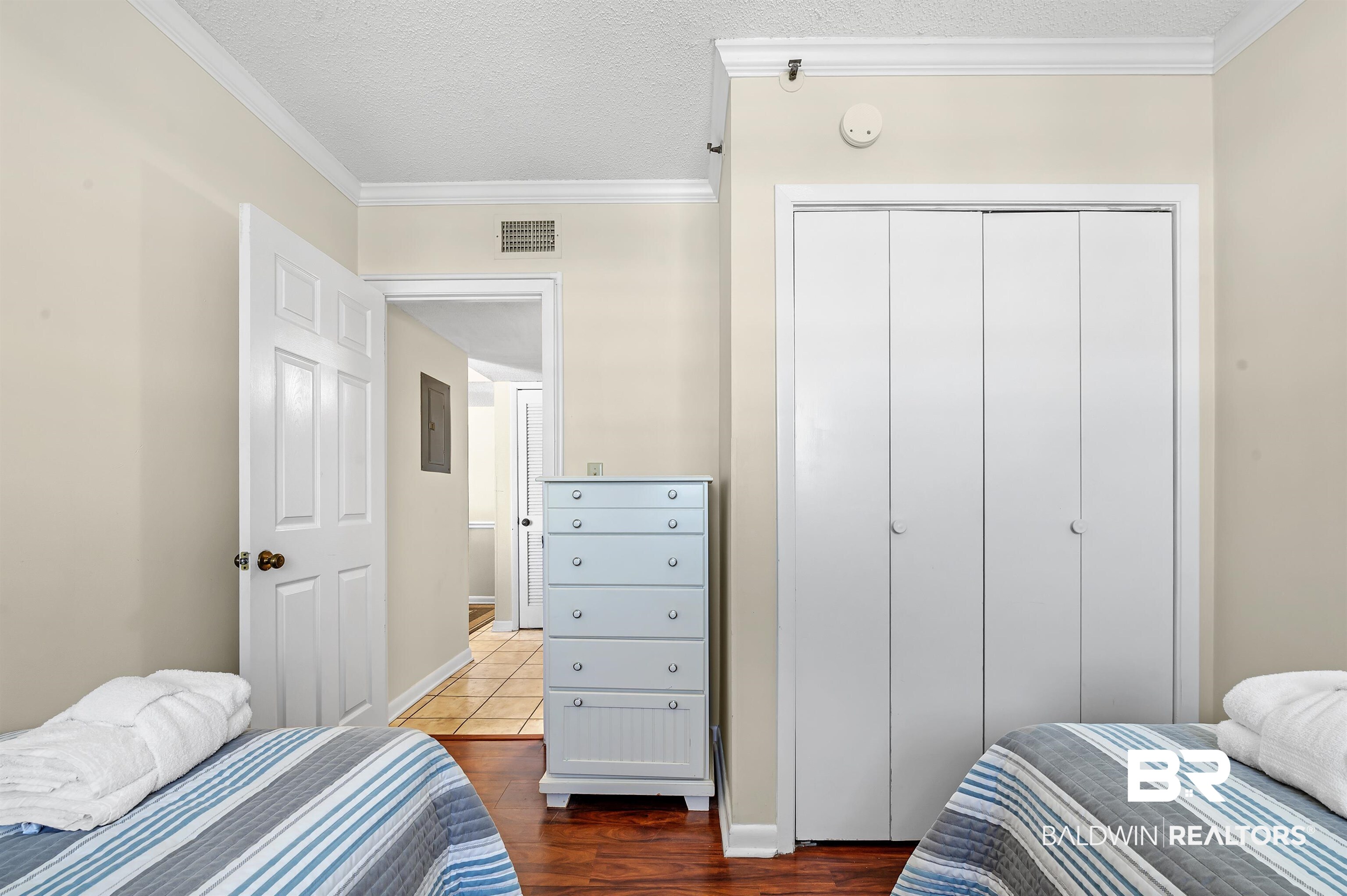 375 Plantation Road, Unit 5409 Gulf Shores, AL 36542 - Photo 25 of 48 Bedroom with ornamental molding, a closet, hardwood / wood-style floors, and a textured ceiling