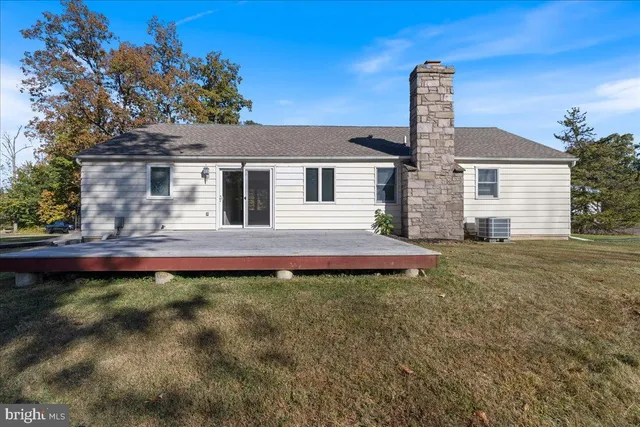 a view of big yard next to a house with large trees