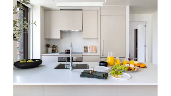 a kitchen with stainless steel appliances granite countertop a sink a stove and a wooden floor