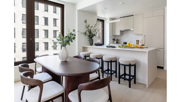 a kitchen with a dining table chairs and white cabinets