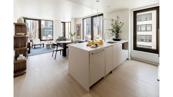 a dining room with furniture and large windows