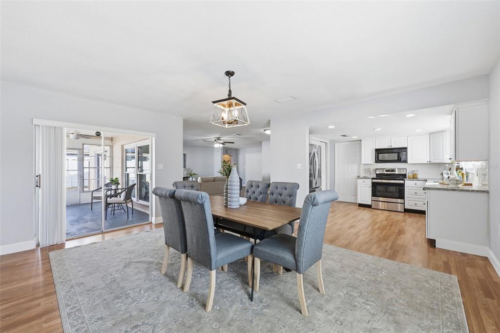 8233 Redfield Drive Port Richey, FL 34668 - Photo 13 of 36 a view of a dining room and livingroom with furniture wooden floor a rug and a chandelier