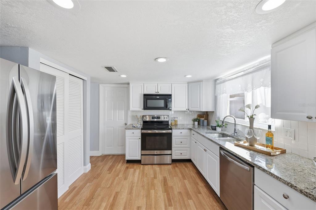 8233 Redfield Drive Port Richey, FL 34668 - Photo 15 of 36 a kitchen with stainless steel appliances granite countertop a refrigerator stove and sink