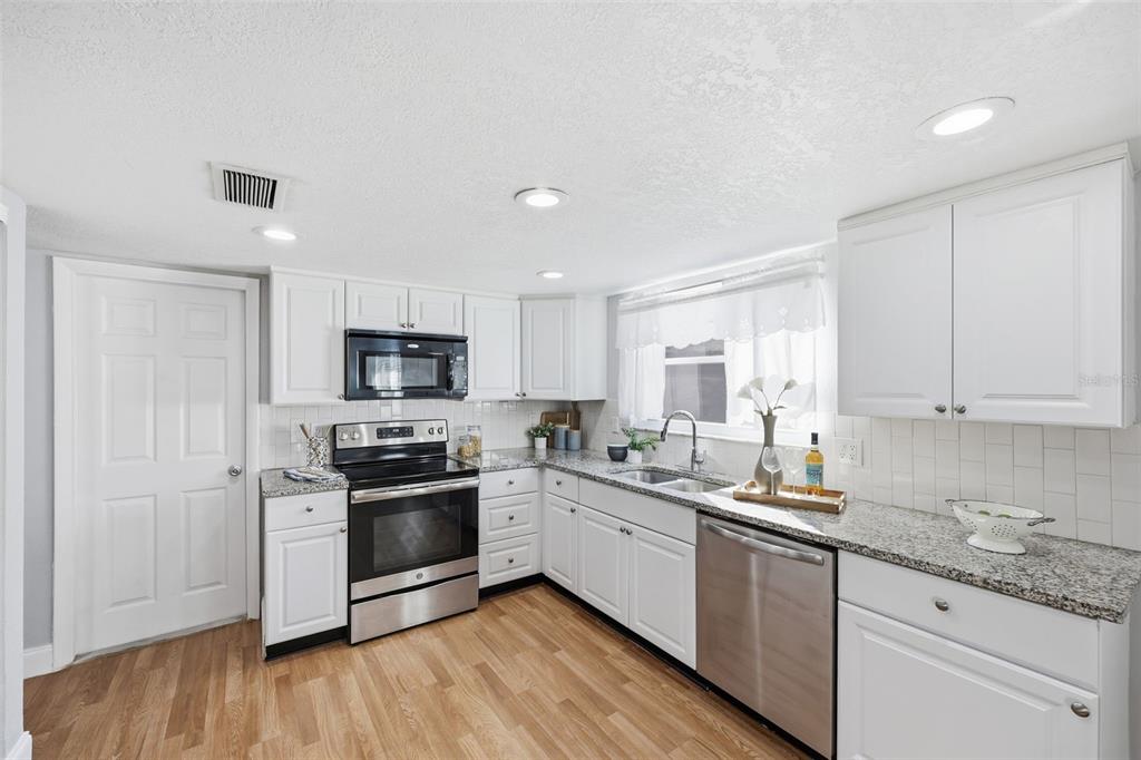 8233 Redfield Drive Port Richey, FL 34668 - Photo 16 of 36 a kitchen with granite countertop a sink and steel appliances