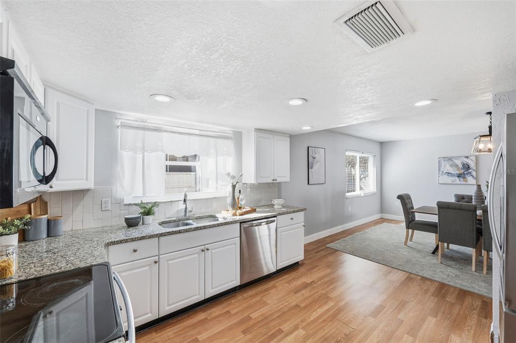 8233 Redfield Drive Port Richey, FL 34668 - Photo 18 of 36 a kitchen with a sink cabinets and wooden floor