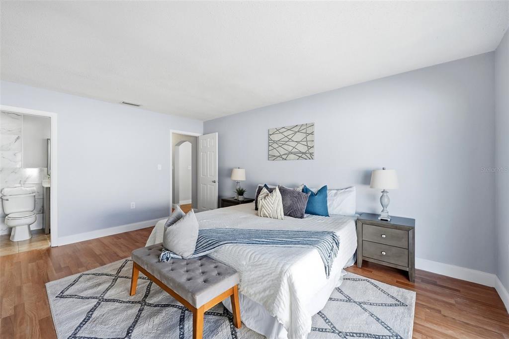 8233 Redfield Drive Port Richey, FL 34668 - Photo 21 of 36 a bedroom with a bed a rug and wooden floor