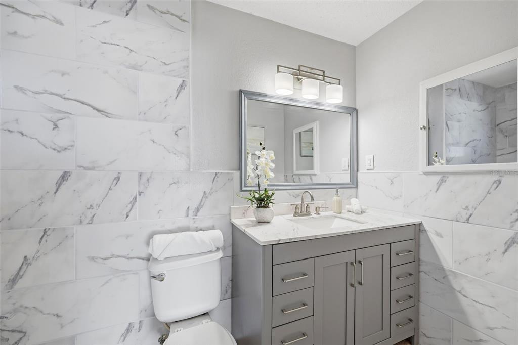 8233 Redfield Drive Port Richey, FL 34668 - Photo 26 of 36 a bathroom with a sink vanity toilet and shower