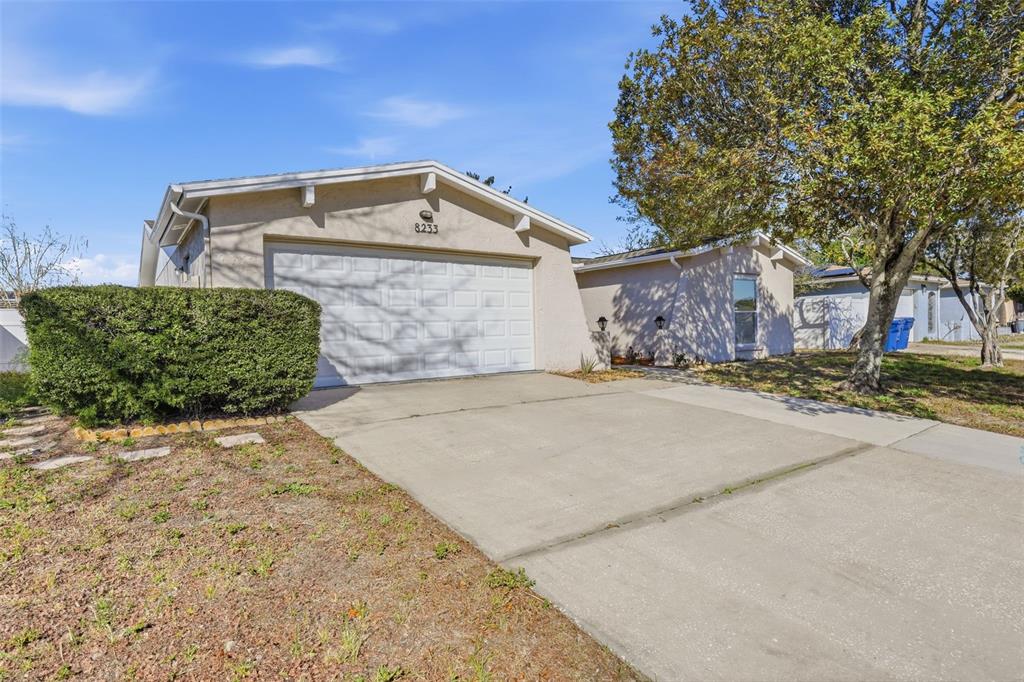 8233 Redfield Drive Port Richey, FL 34668 - Photo 3 of 36 front view of a house with a yard