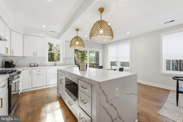 a dining room with wooden floor a chandelier a wooden table and chairs