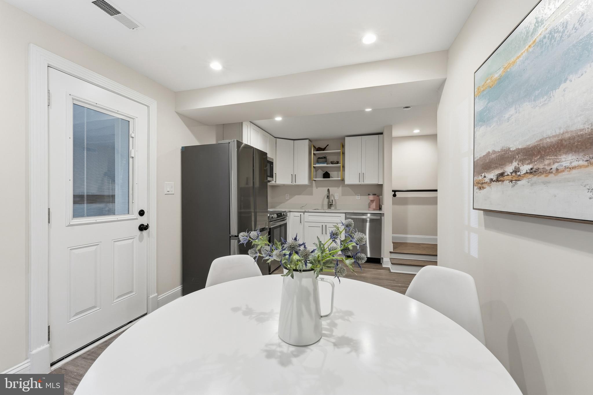 1524 Allison Street Northwest Washington, DC 20011 - Photo 45 of 85 a kitchen with stainless steel appliances a dining table chairs and granite counter tops