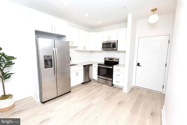 a kitchen with stainless steel appliances a refrigerator sink and stove