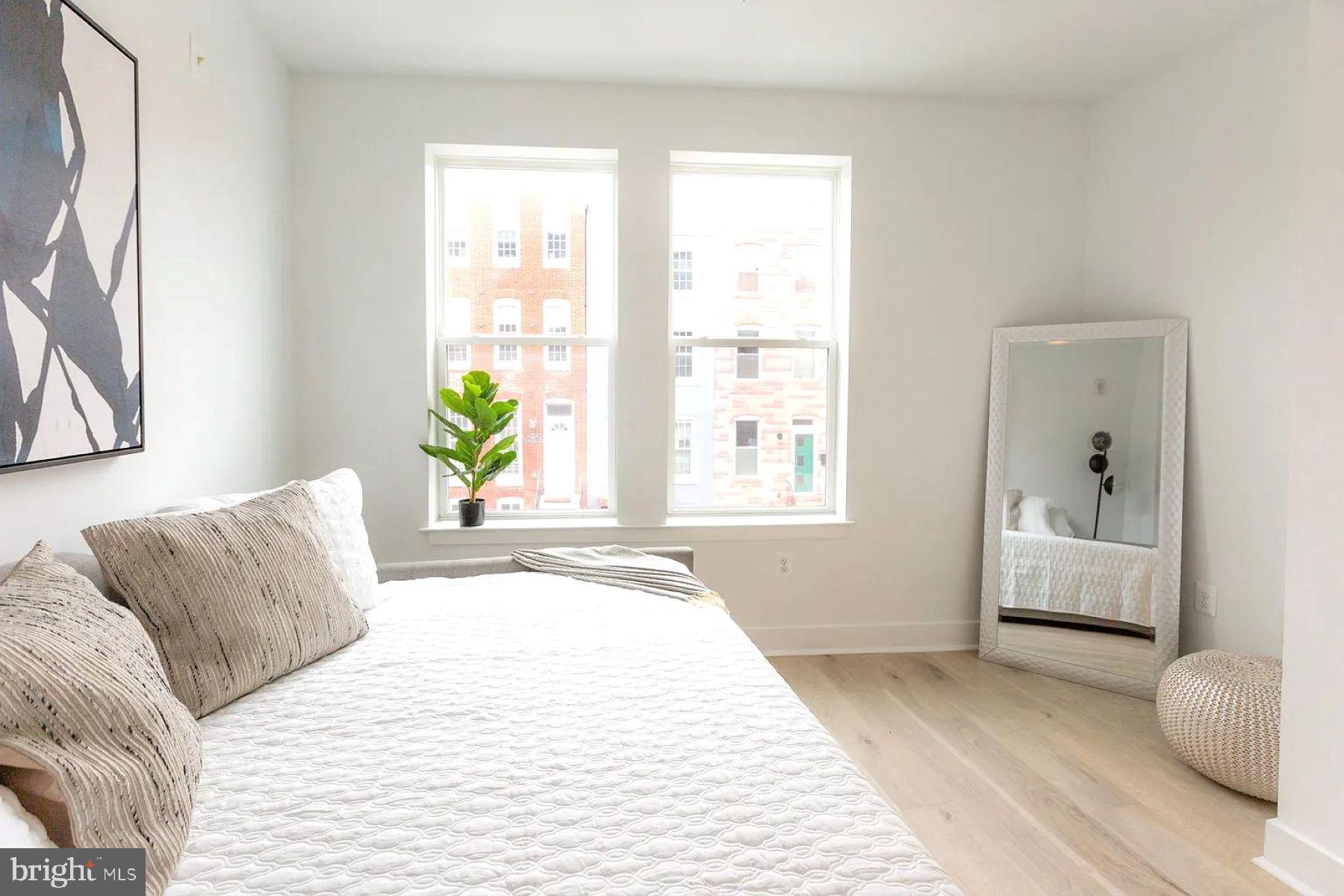 1702 Light Street, Unit 203 Baltimore, MD 21230 - Photo 6 of 14 a bedroom with a bed and sliding window