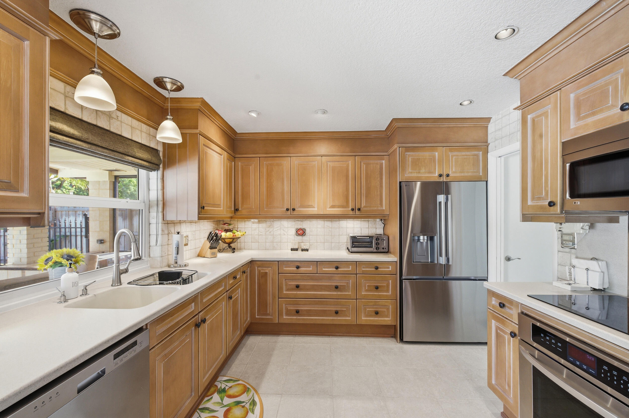 4780 Brandywine Drive Boca Raton, FL 33487 - Photo 12 of 43 a kitchen with stainless steel appliances a sink cabinets and a window