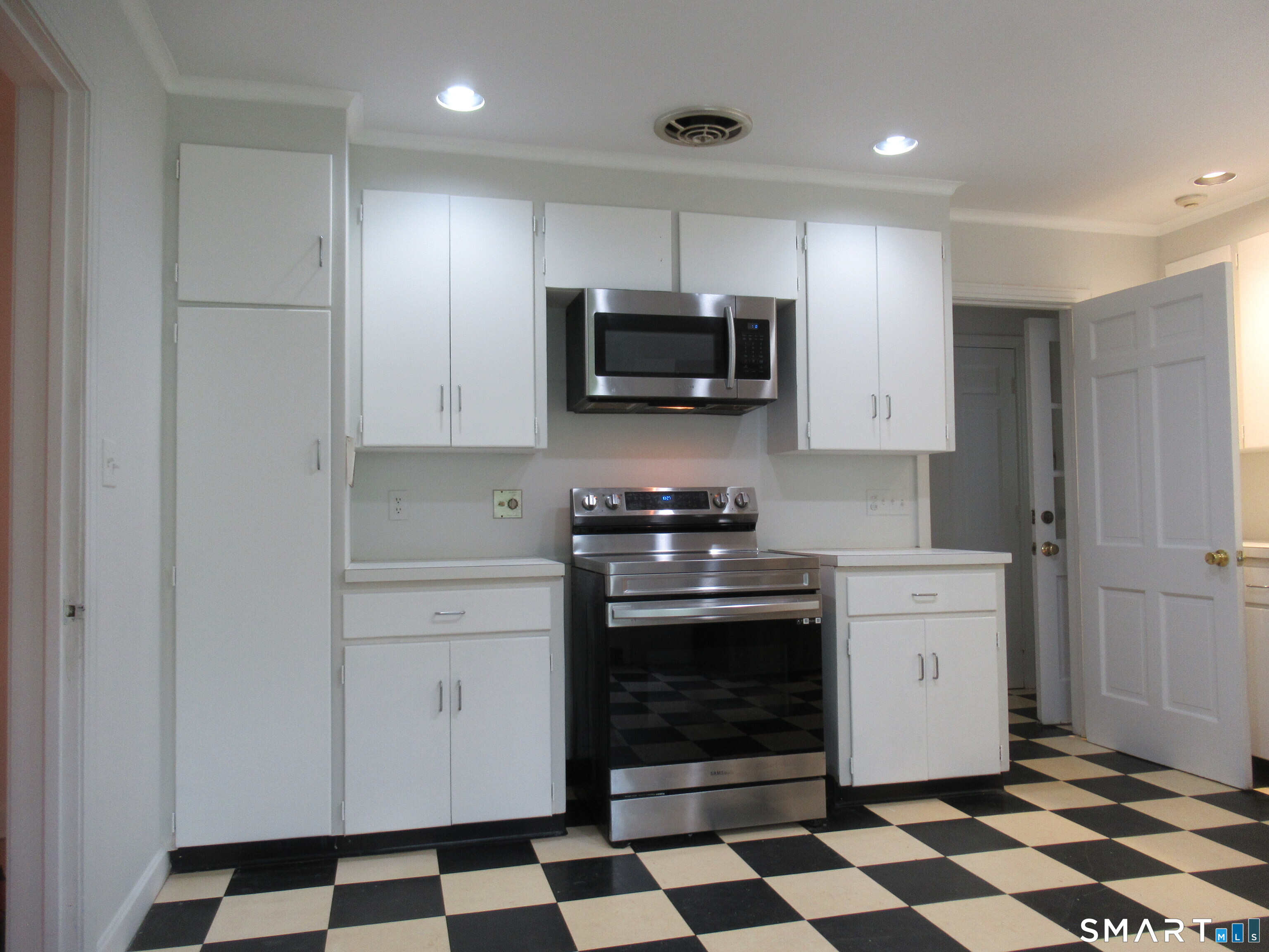 11 Burnt Swamp Road Woodbridge, CT 06525 - Photo 10 of 29 a kitchen with a stove a microwave and cabinets
