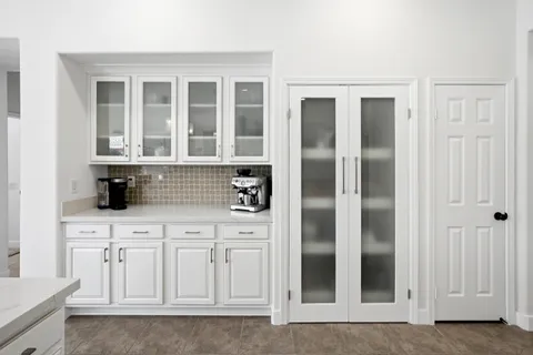 a kitchen with white cabinets and refrigerator