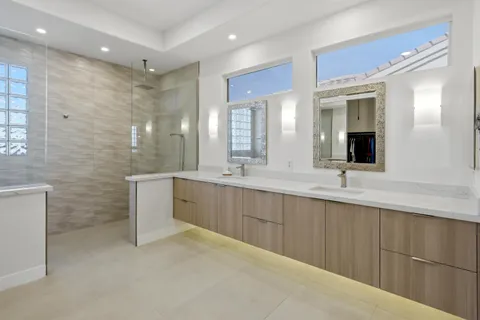 a spacious bathroom with a double vanity sink a mirror and a bathtub