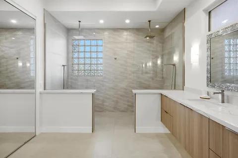 a bathroom with a double vanity sink a mirror and shower