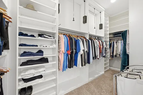 a view of walk in closet with clothes and shoes