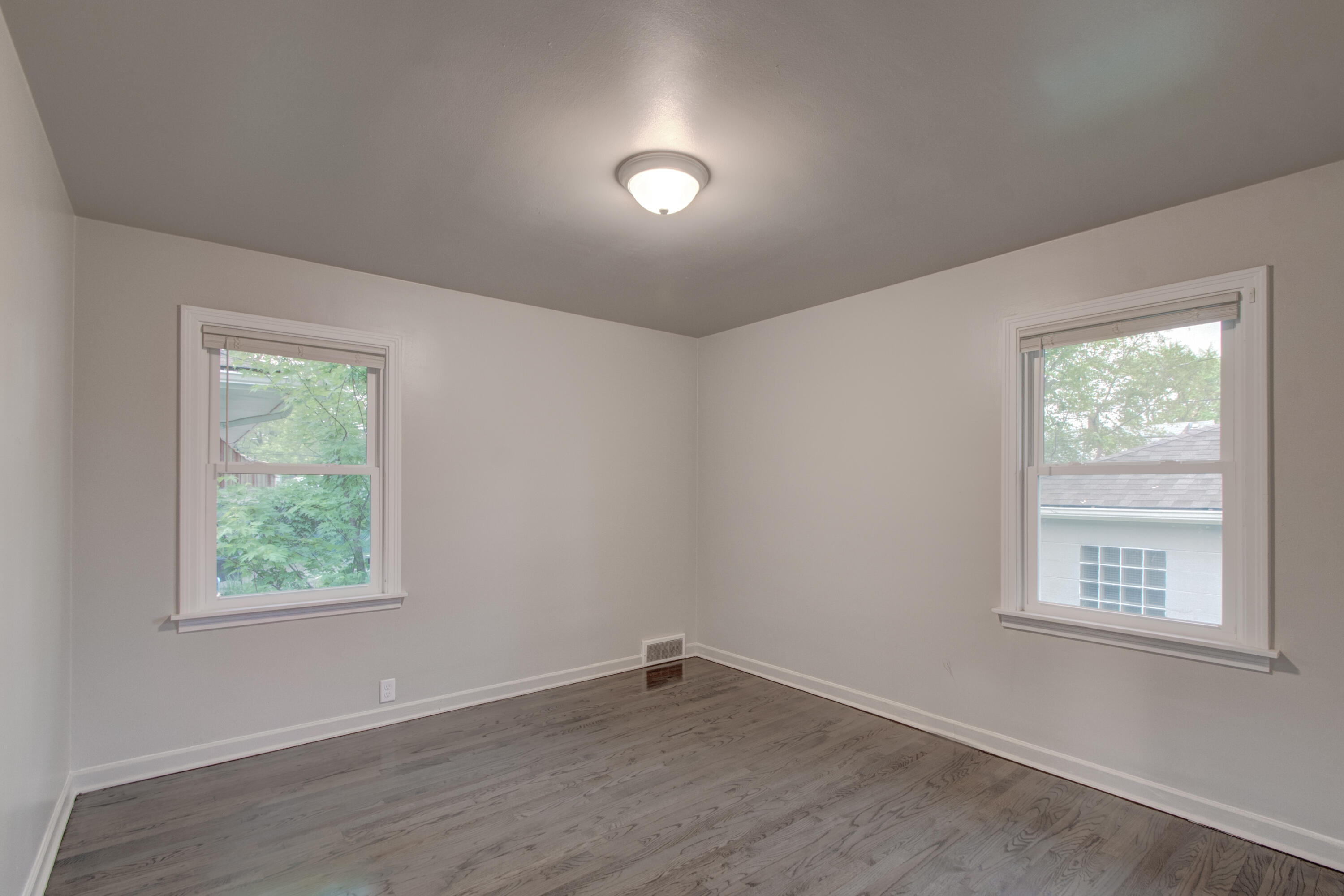 4727 Harrison Street Gary, IN 46408 - Photo 11 of 15 an empty room with wooden floor and windows