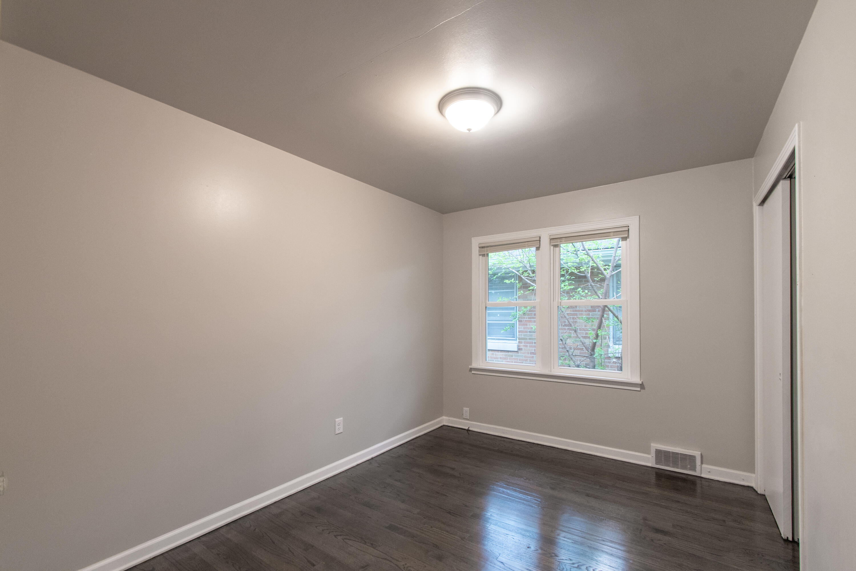 4727 Harrison Street Gary, IN 46408 - Photo 9 of 15 an empty room with wooden floor and windows