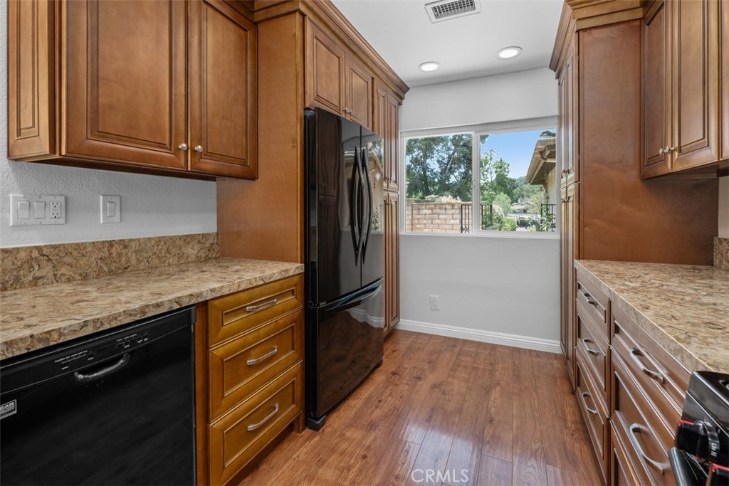 4346 Los Padres Drive Fallbrook, CA 92028 - Photo 11 of 31 a kitchen with granite countertop wooden cabinets a refrigerator and a sink