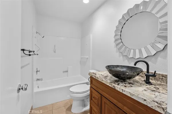 a bathroom with a granite countertop sink a toilet and bathtub