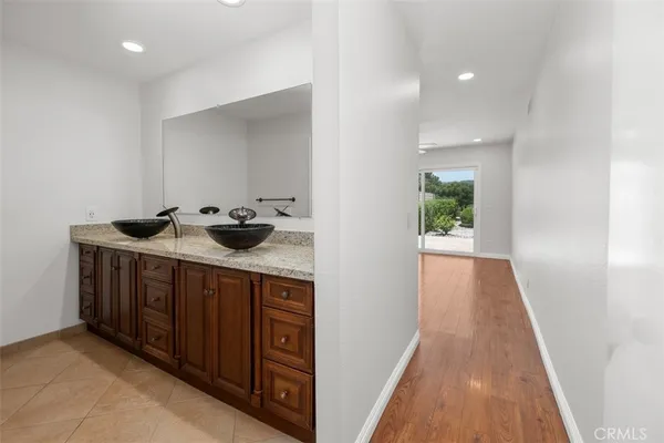 a hallway with sink and wooden floor