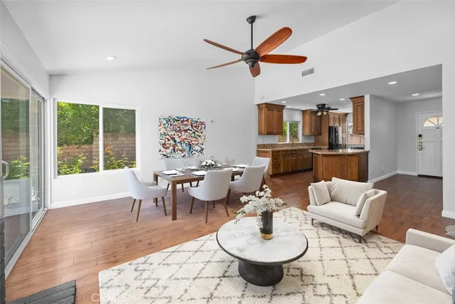 a living room with furniture kitchen view and a large window