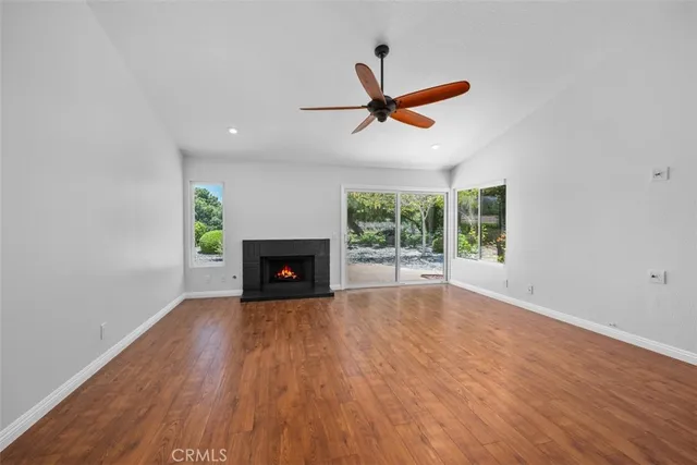 a view of empty room with wooden floor and fireplace