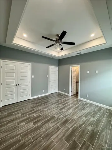 a view of an empty room with cabinet and a ceiling fan
