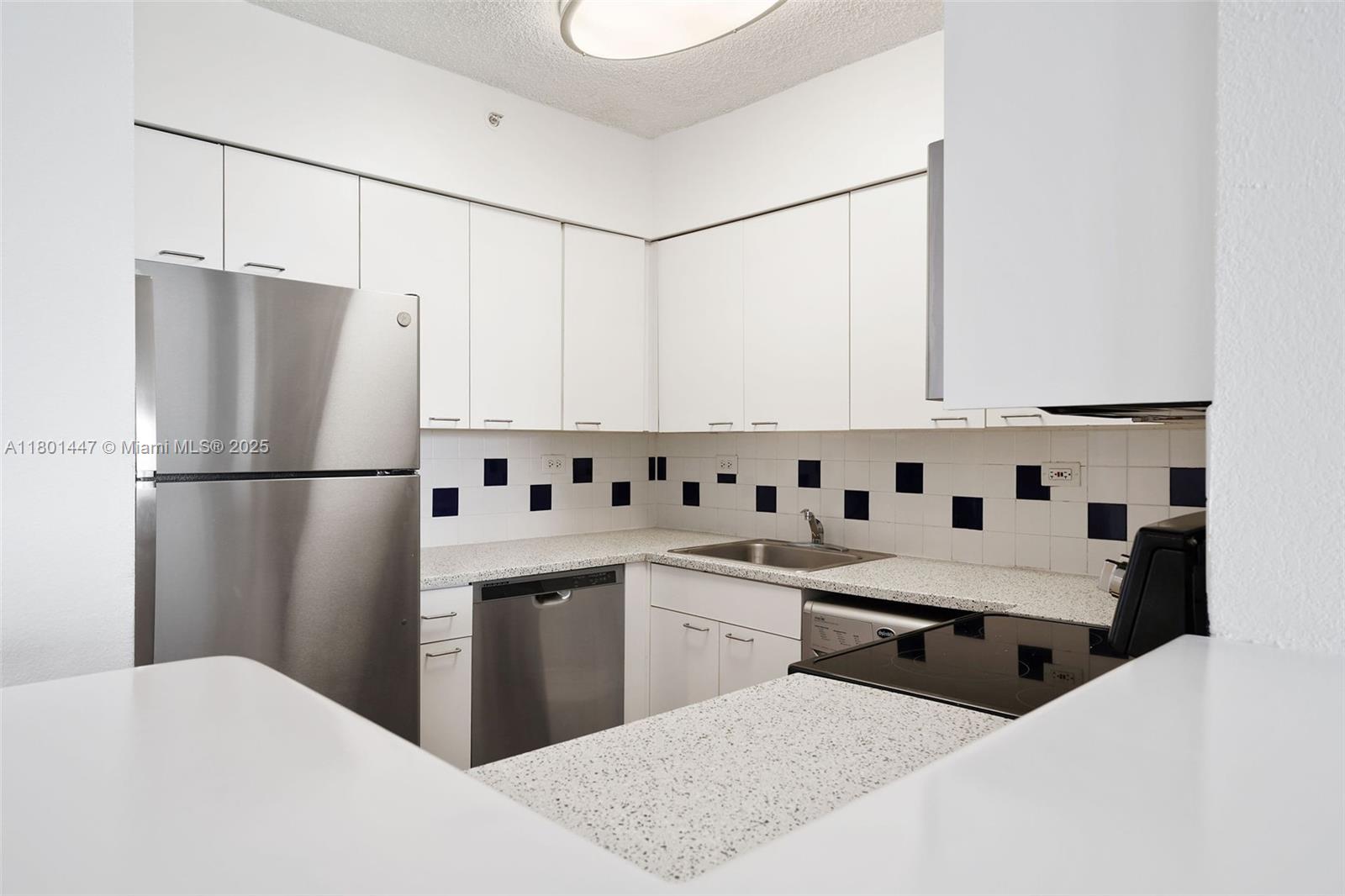 1500 Bay Road, Unit S0380 Miami Beach, FL 33139 - Photo 6 of 83 a kitchen with stainless steel appliances a sink a refrigerator and white cabinets