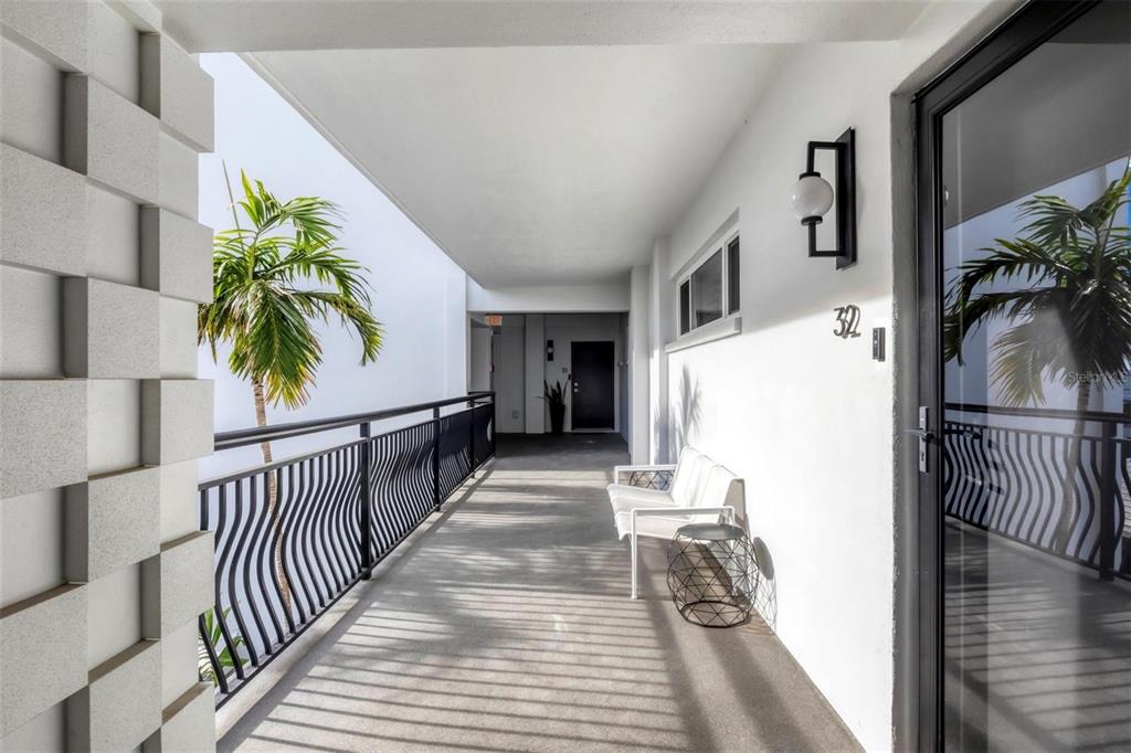 226 Golden Gate Point, Unit 32 Sarasota, FL 34236 - Photo 11 of 60 a view of a hallway to a house with wooden floor