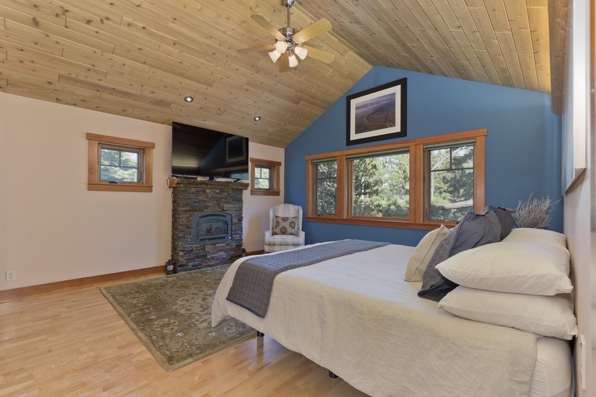 2500 Old Mammoth Road Mammoth Lakes, CA 93546 - Photo 27 of 48 a bedroom with a large bed a flat tv screen and a fireplace