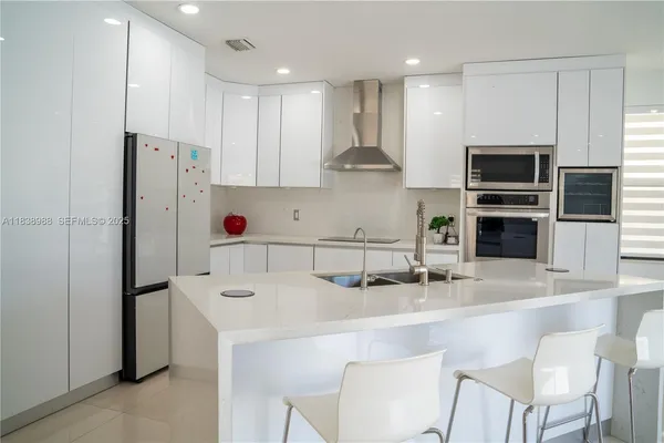 a kitchen with stainless steel appliances a refrigerator and a stove top oven