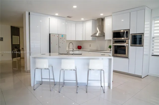 a kitchen with stainless steel appliances kitchen island granite countertop a refrigerator and a stove top oven