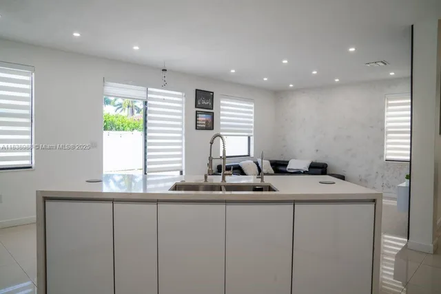 a kitchen with kitchen island granite countertop a sink and a window