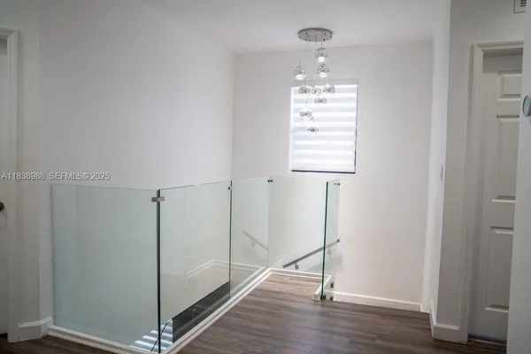 a view of a hallway with wooden floor and closet