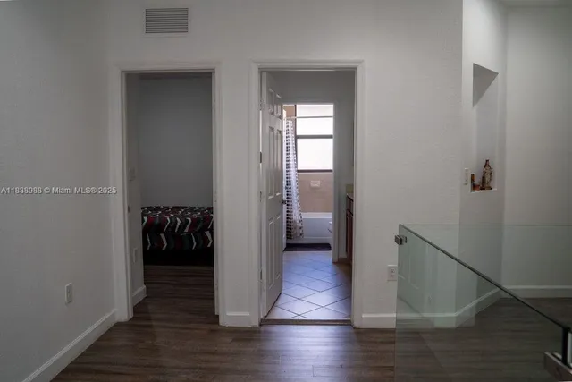 a view of a hallway with wooden floor and closet